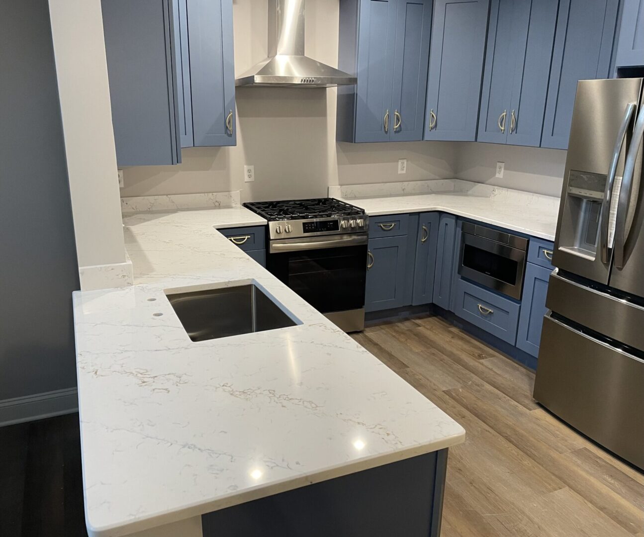 Modern kitchen with blue cabinets and quartz counters.