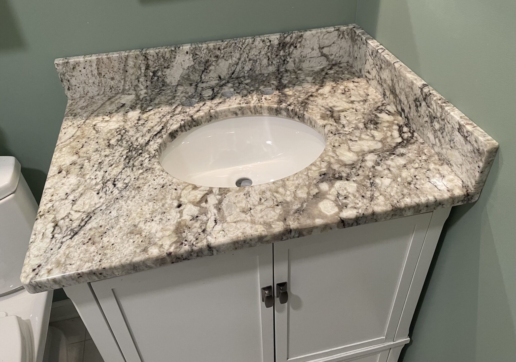 Granite countertop bathroom vanity with sink.