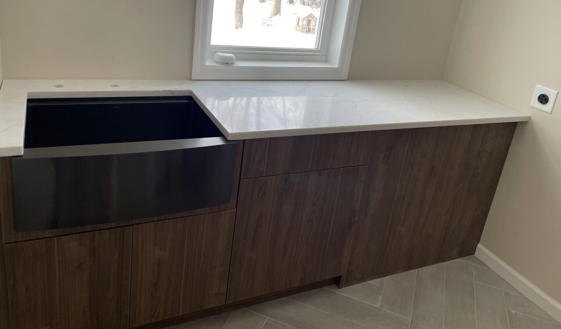 Dark farmhouse sink and wood cabinets.