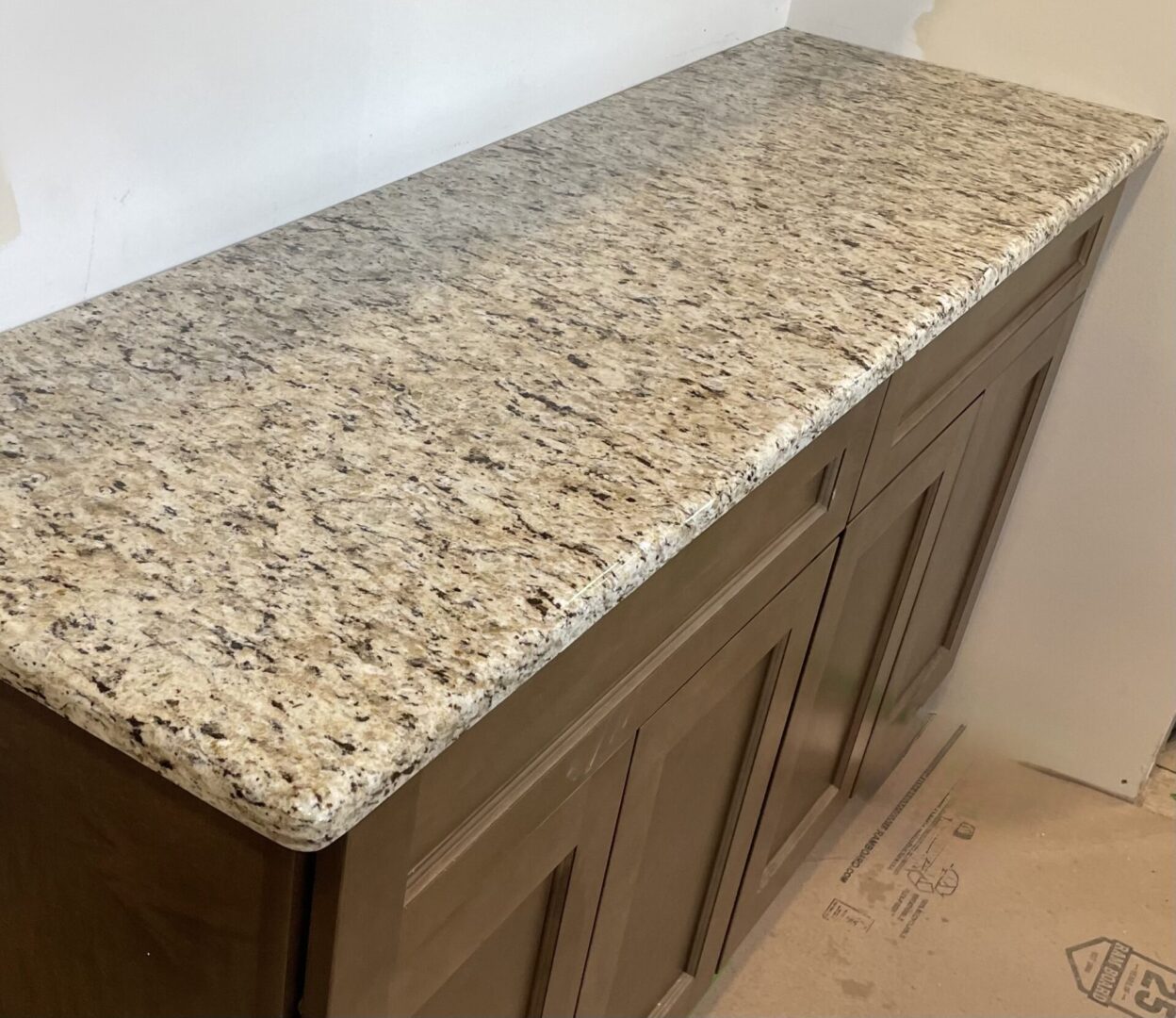 Granite countertop on brown cabinets.