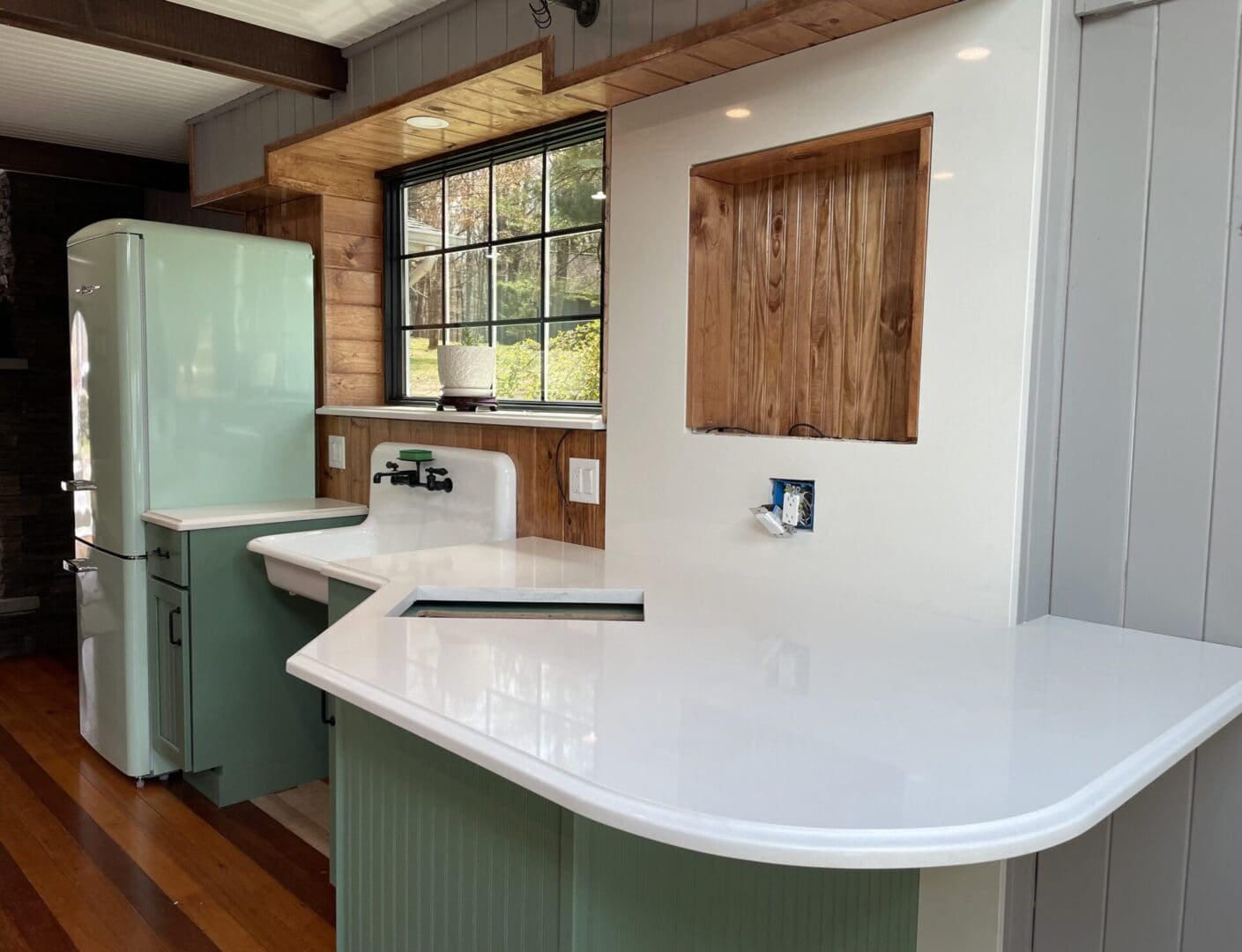 White quartz countertop and mint green cabinets.
