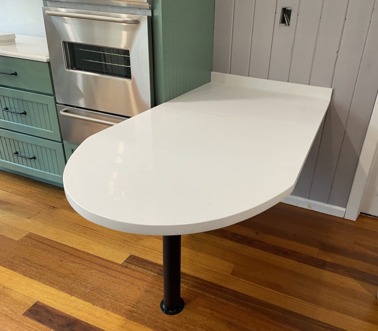 White curved kitchen counter on single leg.