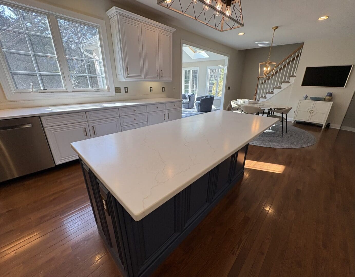 Navy island with white quartz countertop and windows
