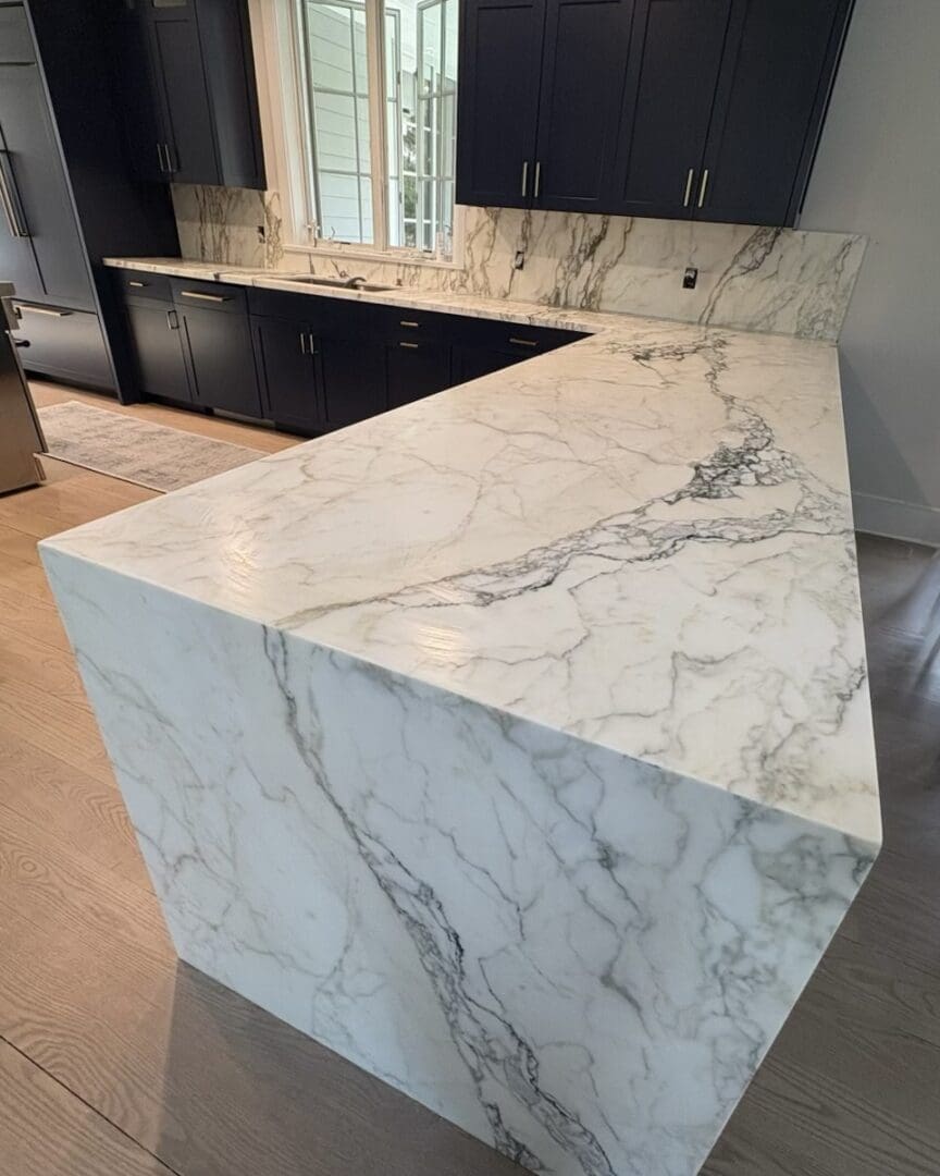 Marble kitchen countertop with dark cabinets.
